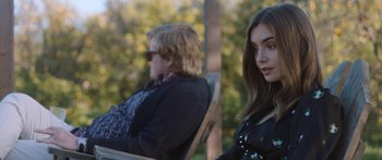 Movie still from “Windfall” (2022), directed by Charlie McDowell – A woman sitting next to another woman on a chair; Medium shot, Over the shoulder angle