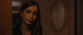 Movie still from “Windfall” (2022), directed by Charlie McDowell – A person with long brown hair; Close Up shot, Over the shoulder angle