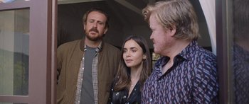 Movie still from “Windfall” (2022), directed by Charlie McDowell – Two men and a woman standing next to each other; Medium shot, Over the shoulder angle