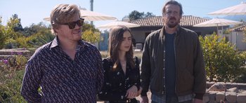 Movie still from “Windfall” (2022), directed by Charlie McDowell – A group of people standing next to each other on a street; Medium shot, Over the shoulder angle