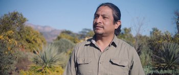 Movie still from “Windfall” (2022), directed by Charlie McDowell – A person standing in a field; Medium shot, Low angle