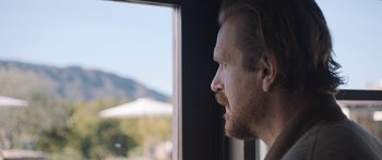Movie still from “Windfall” (2022), directed by Charlie McDowell – A person looking out of a window; Close Up shot, Over the shoulder angle