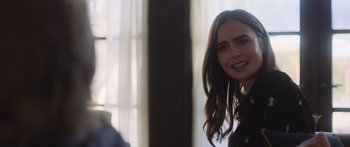 Movie still from “Windfall” (2022), directed by Charlie McDowell – A person with long brown hair; Close Up shot, Over the shoulder angle