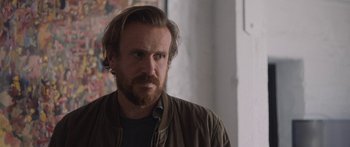 Movie still from “Windfall” (2022), directed by Charlie McDowell – A person with a beard; Close Up shot, Over the shoulder angle