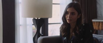 Movie still from “Windfall” (2022), directed by Charlie McDowell – A woman sitting in a chair in front of a window; Close Up shot, Over the shoulder angle