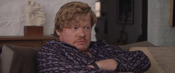 Movie still from “Windfall” (2022), directed by Charlie McDowell – A person sitting on a couch; Close Up shot, Over the shoulder angle