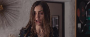 Movie still from “Windfall” (2022), directed by Charlie McDowell – A person with long brown hair; Close Up shot, Over the shoulder angle