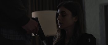 Movie still from “Windfall” (2022), directed by Charlie McDowell – A woman holding a gun in her hand; Close Up shot, Over the shoulder angle