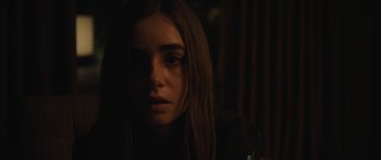 Movie still from “Windfall” (2022), directed by Charlie McDowell – A woman with long hair is looking at the camera; Close Up shot, High angle