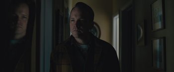 Movie still from “Wormwood” (2017), directed by Errol Morris – A man standing in the dark in front of a window; Close Up shot, Low angle
