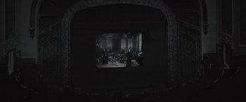 Movie still from “Wormwood” (2017), directed by Errol Morris – A view of a theater from the back of the stage; Extreme Wide shot, High angle