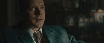Movie still from “Wormwood” (2017), directed by Errol Morris – A person wearing a suit and tie; Close Up shot, Over the shoulder angle