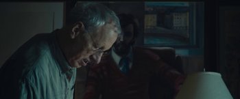 Movie still from “Wormwood” (2017), directed by Errol Morris – A man in a suit and tie standing next to another man in a suit and tie; Close Up shot, Over the shoulder angle