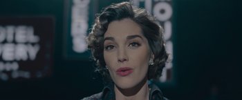 Movie still from “Wormwood” (2017), directed by Errol Morris – A person with short curly hair; Close Up shot, Low angle