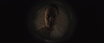 Movie still from “Wormwood” (2017), directed by Errol Morris – A man is looking into a camera lens; Close Up shot, Low angle