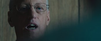 Movie still from “Wormwood” (2017), directed by Errol Morris – An older man wearing glasses and a white beard; Close Up shot, Over the shoulder angle