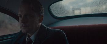 Movie still from “Wormwood” (2017), directed by Errol Morris – A man sitting in a car looking out the window; Close Up shot, Over the shoulder angle