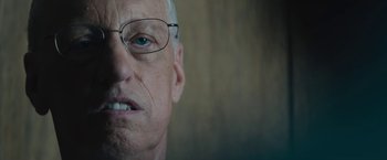 Movie still from “Wormwood” (2017), directed by Errol Morris – An older man wearing glasses looking at the camera; Close Up shot, Low angle