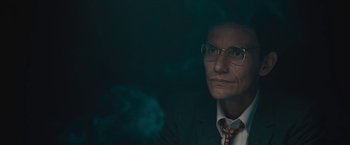 Movie still from “Wormwood” (2017), directed by Errol Morris – A man wearing glasses and a suit and tie; Close Up shot, Low angle