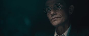 Movie still from “Wormwood” (2017), directed by Errol Morris – An older man wearing glasses looking at the camera; Close Up shot, Low angle