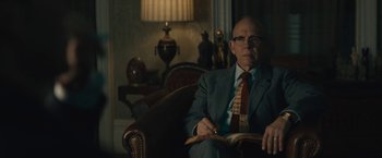 Movie still from “Wormwood” (2017), directed by Errol Morris – An older man sitting in a chair in a room; Medium shot, Low angle