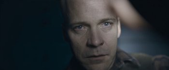 Movie still from “Wormwood” (2017), directed by Errol Morris – A person's face in a dark room; Extreme Close Up shot, Over the shoulder angle