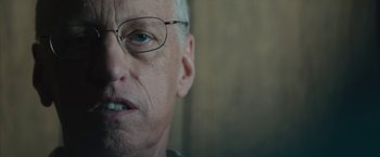 Movie still from “Wormwood” (2017), directed by Errol Morris – An older man wearing glasses looking at the camera; Close Up shot, Low angle