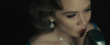 Movie still from “Wormwood” (2017), directed by Errol Morris – A person wearing a necklace and earrings; Close Up shot, Over the shoulder angle