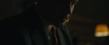 Movie still from “Wormwood” (2017), directed by Errol Morris – A person wearing a suit and tie; Extreme Close Up shot, Low angle