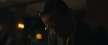 Movie still from “Wormwood” (2017), directed by Errol Morris – A man with glasses is smoking a cigarette; Close Up shot, Over the shoulder angle