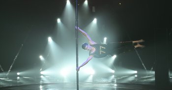 Movie still from “Yeh Ballet” (2020), directed by Sooni Taraporevala – A man on a pole in the middle of a dance floor; Wide shot, Low angle