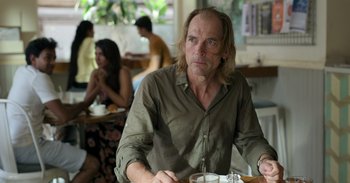 Movie still from “Yeh Ballet” (2020), directed by Sooni Taraporevala – A man sitting at a table in front of a plate of food; Medium shot, Over the shoulder angle