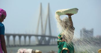 Movie still from “Yeh Ballet” (2020), directed by Sooni Taraporevala – An old woman is holding a tray of flour; Wide shot, Low angle