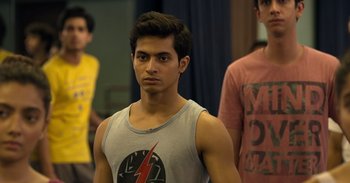Movie still from “Yeh Ballet” (2020), directed by Sooni Taraporevala – A young man in a tank top is standing in front of two other young men; Close Up shot, Over the shoulder angle