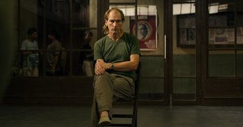 Movie still from “Yeh Ballet” (2020), directed by Sooni Taraporevala – A man sitting on a chair in front of a window; Medium shot, Low angle