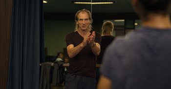 Movie still from “Yeh Ballet” (2020), directed by Sooni Taraporevala – A man standing in front of a mirror clapping his hands; Medium shot, Over the shoulder angle