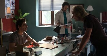 Movie still from “Yeh Ballet” (2020), directed by Sooni Taraporevala – A man standing at a counter in front of two other men; Wide shot, High angle