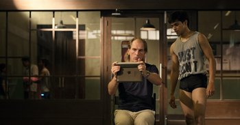 Movie still from “Yeh Ballet” (2020), directed by Sooni Taraporevala – A man sitting in a chair looking at an ipad; Medium shot, Low angle
