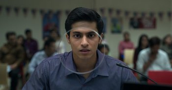 Movie still from “Yeh Ballet” (2020), directed by Sooni Taraporevala – A young man wearing a blue shirt and a white circle around his face; Close Up shot, Low angle
