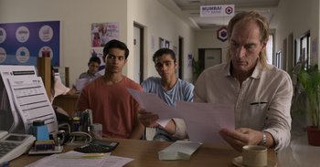 Movie still from “Yeh Ballet” (2020), directed by Sooni Taraporevala – A group of people sitting at a table looking at papers; Medium shot, Low angle