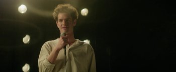 Movie still from “tick, tick... BOOM!” (2021), directed by Lin-Manuel Miranda – A man standing on a stage with a microphone in front of him; Close Up shot, Over the shoulder angle