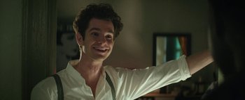 Movie still from “tick, tick... BOOM!” (2021), directed by Lin-Manuel Miranda – A man with curly hair smiling and waving; Close Up shot, Over the shoulder angle