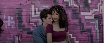 Movie still from “tick, tick... BOOM!” (2021), directed by Lin-Manuel Miranda – A man and a woman are sitting next to each other in front of a wall; Medium shot, Overhead angle
