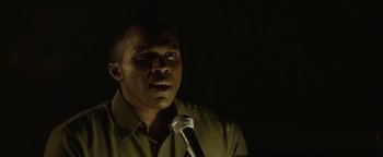 Movie still from “tick, tick... BOOM!” (2021), directed by Lin-Manuel Miranda – A man standing in front of a microphone in the dark; Close Up shot, Low angle