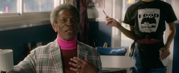 Movie still from “tick, tick... BOOM!” (2021), directed by Lin-Manuel Miranda – An older man wearing a plaid jacket and a pink turtleneck; Close Up shot, Over the shoulder angle