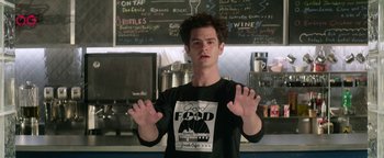 Movie still from “tick, tick... BOOM!” (2021), directed by Lin-Manuel Miranda – A man in a black shirt is holding his hands up in front of him; Medium shot, Low angle