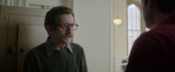 Movie still from “tick, tick... BOOM!” (2021), directed by Lin-Manuel Miranda – A man wearing glasses and a green sweater looks at the camera; Close Up shot, Over the shoulder angle