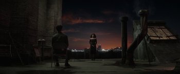 Movie still from “tick, tick... BOOM!” (2021), directed by Lin-Manuel Miranda – A woman in a black dress standing in front of a man in a black suit; Extreme Wide shot, Over the shoulder angle