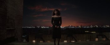Movie still from “tick, tick... BOOM!” (2021), directed by Lin-Manuel Miranda – A woman in a black dress standing in front of a city skyline; Wide shot, Low angle