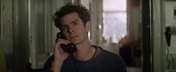 Movie still from “tick, tick... BOOM!” (2021), directed by Lin-Manuel Miranda – A man is talking on a phone while sitting in a room; Close Up shot, Low angle